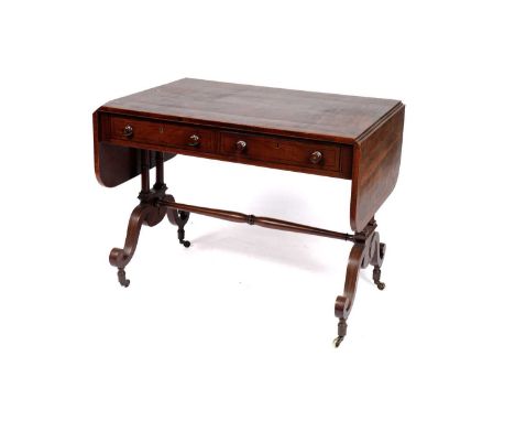 A Regency mahogany and rosewood crossbanded sofa table, the rectangular double flap top above a real and dummy drawer to each