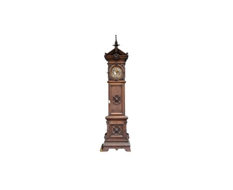 An early 20th Century German walnut longcase clock, with silvered metal and brass roman dial, the case with ornate tall centr