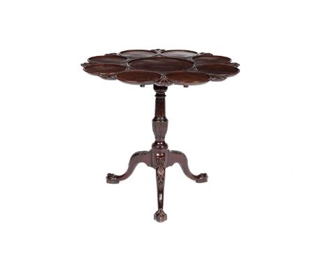 A Georgian mahogany tilt action supper table, with eight settings, the fluted and leaf carved stem, raised on a tripod base w