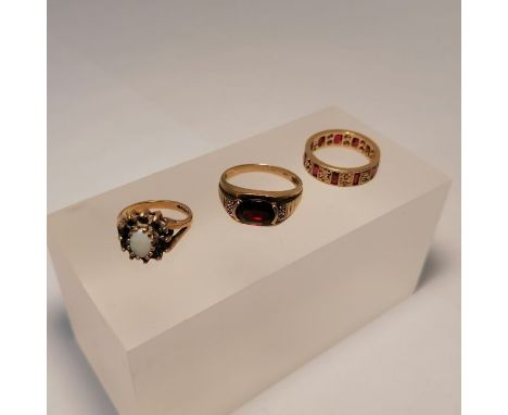 Three gem set 9ct gold rings. Featuring a garnet and diamond ring, size S; a sapphire and opal ring, size J; a ruby and cubic