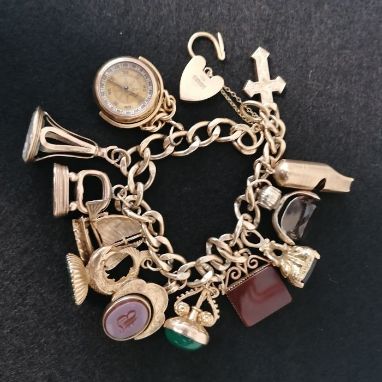 A 9ct gold charm bracelet. Each link features a partial hallmark featuring 375 stamped links, with a fully hallmarked heart p