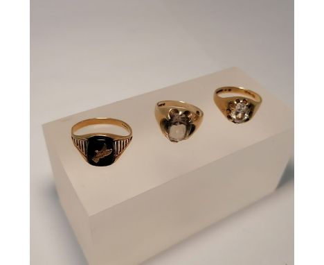 A collection of gentlemen's 9ct gold gem set rings. Featuring a onyx ring, with an eagle on, size U; a rock crystal set ring,