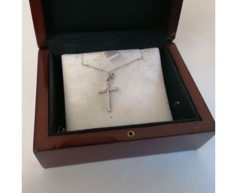 A 750 stamped white metal cross, set with round cut diamonds on a beaded chain. Gross weight approximately 3.1 grams. Signed 