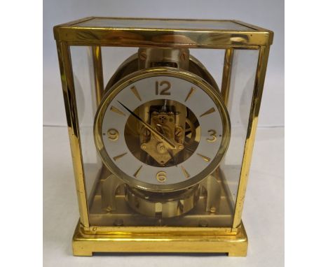 A mid century Jaeger leCoulture gilt brass Atmos clock with a circular dial and Arabic numerals. Ring shaped balance. This cl
