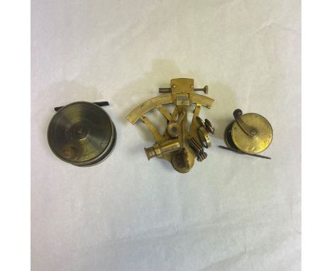 A solid brass sextant, unbranded and country of origin unknown. Approximately 13cmAlong with a brass salmon fly reel, late 19