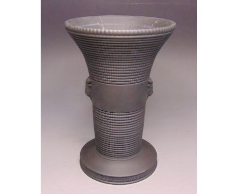 A Wedgwood black basalt vase, engine turned, the central plain band has rams heads attached, circa 1953, marked WEDGWOOD, Mad