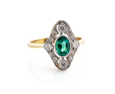 An Edwardian emerald and diamond ring, the elongated diamond shape, set to the centre with an oval emerald with a halo of gra