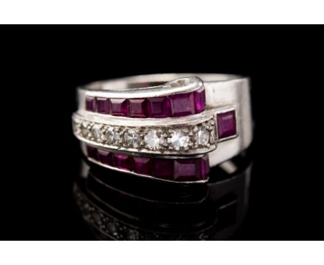 An Art Deco ruby and diamond set platinum scroll band ring, the three row graduating band comprising a central row of round e