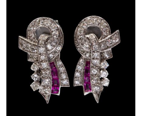 A pair of Art Deco diamond and ruby set clips, the stylised ribbon bow design, comprising claw and grain set round old eight 