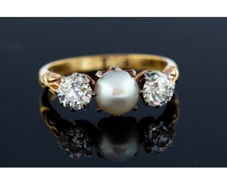 A Victorian  pearl and diamond  three stone ring, the central button shaped pearl approx 6.5mm diameter, two round old cut di