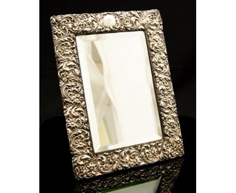 An Edwardian silver framed easel looking glass, repousse frame with scrolling flowers and foliage, Birmingham 1901, 24cm by 1