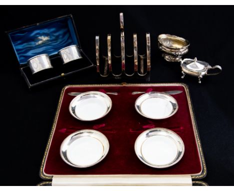 A collection of table silver including: A set of four George V silver circular butter dishes and a pair of butter knives, wit