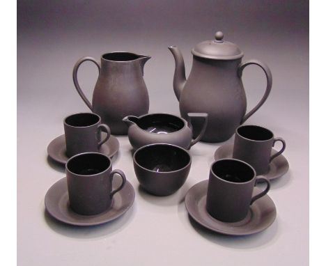 A Wedgwood black basalt coffee set, coffee pot, water jug, cream jug, sucrier,  four cans and four saucers, the inside is bla