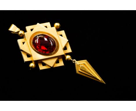 A Victorian Gothic style garnet set drop pendant, the central oval cabochon cut garnet measuring approx 16mm x 12mm, a square