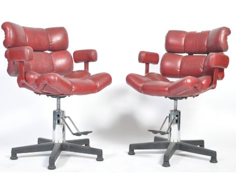 A pair of late 20th century retro vintage salon / barber chairs having four rolled cushions creating the seat and backrest wi