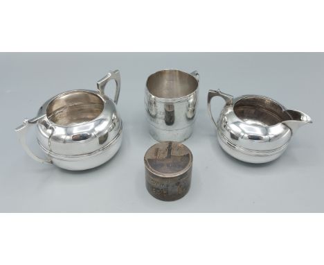 An Indian white metal two handled sucrier together with a matching cream jug, a white metal Niello cylindrical box and cover 