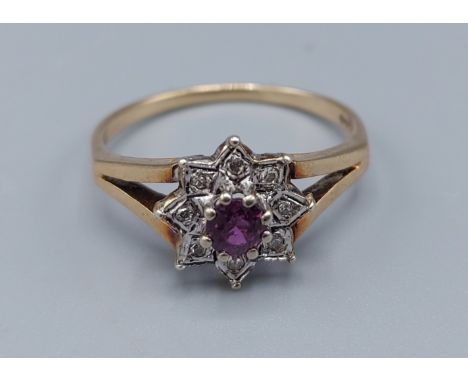 A 9ct gold cluster ring set with a central Amethyst surrounded by diamonds within a pierced setting, 2.4gms, ring size Q 