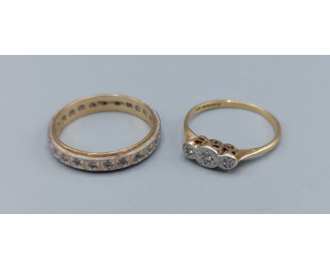 An 18ct gold three stone Diamond ring, 1.5g, together with a 9ct gold diamond set eternity ring, 2.2g 