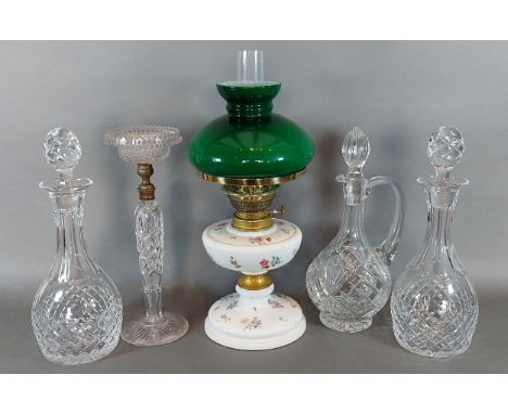 A German porcelain oil lamp marked with blue crossed swords together with three glass decanters and a glass lamp base 