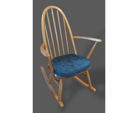 An Ercol blonde Ash rocking chair with spindle back above a panel seat 