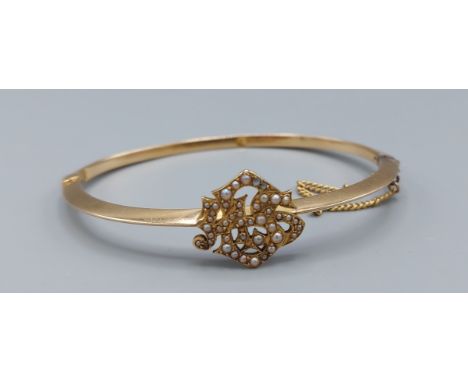 A yellow metal bangle with pearl decoration, 4.5cms by 6cms, 7.7gms 
