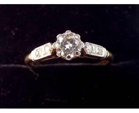 An 18 carat gold ring set diamond on diamond set shoulders