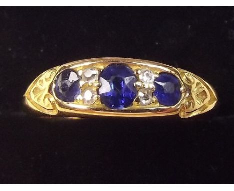 An 18ct gold ring set three sapphires and four diamonds - Size S