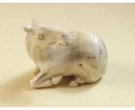 A late 19th century Japanese ivory netsuke carved as recumbent horse - signed to underside