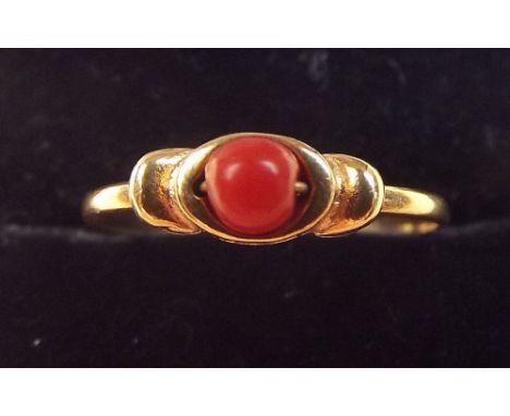 An 18 carat gold ring set coral bead - size P