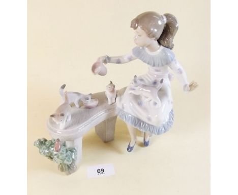 A Lladro group girl seated on a bench with kittens