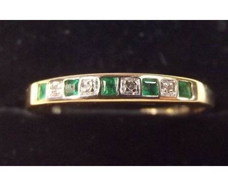 A 9ct gold emerald and diamond line set ring, size N