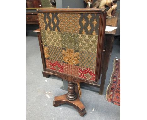 A 19th century mahogany triple action firescreen, with embroidered panels on a turned column with trefoil base  