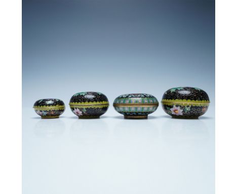 A collection of four Chinese cloisonne lidded boxes, each featuring intricate floral and geometric designs against a black en