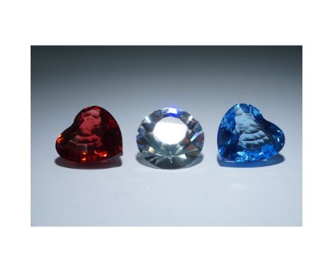 A three-piece collection of Swarovski Crystal Society (SCS) renewal gifts featuring a red heart, a blue heart, and a clear ch