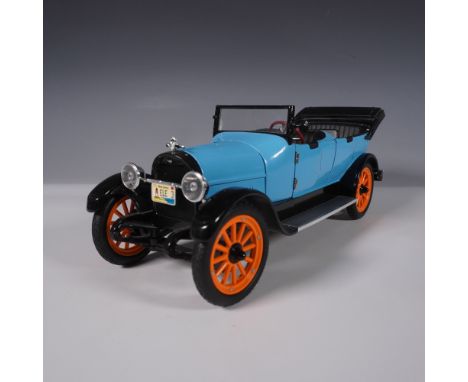 This highly detailed diecast model replicates a classic 1920s touring car with a striking blue body, black fenders, and vibra