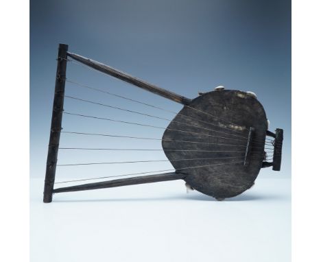 A handcrafted African stringed instrument, possibly a traditional lyre or harp, featuring a rustic wooden frame and a stretch