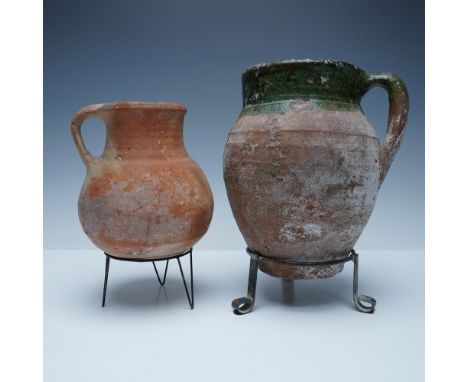 A striking pair of antique handcrafted terracotta pitchers, each exhibiting a beautifully weathered patina. These rustic vess