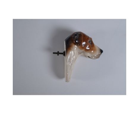 A porcelain dog head wall mount featuring a hand-painted brown and white glaze with a glossy finish. This intricately crafted