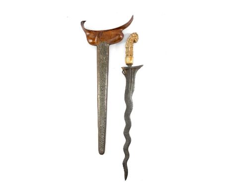 JAVAN KRIS, Madura, with carved hippopotamus ivory hulu, brass mendak, the wrought iron wavy pamor blade within flared wronka