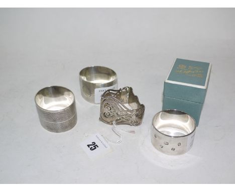 Four silver napkin rings: one of triangular form with pierced decoration, two matching with engine turned decoration, and one