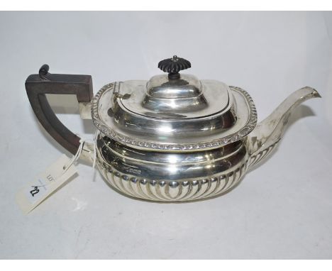 A silver teapot, of half fluted oval form, Sheffield, 1913, 22.7oz gross.