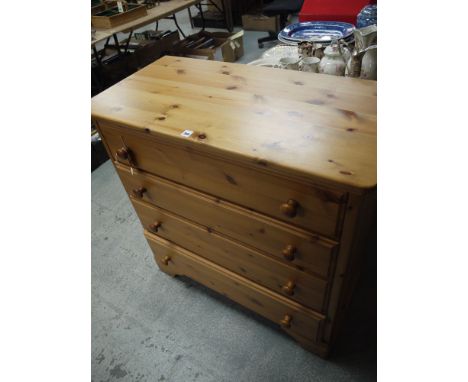 A modern pine chest of four drawers with wood knob handles, raised on bracket feet.