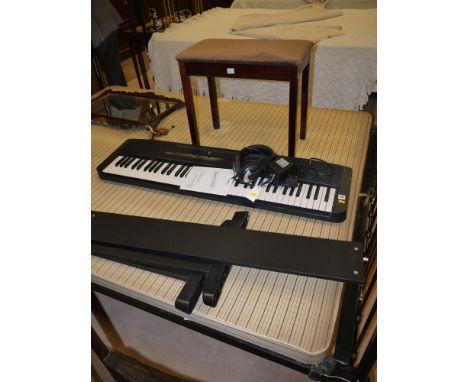 A Casio keyboard and stand, complete with headphones, instruction book; together with a stool.