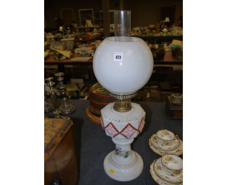 A Victorian glass table oil lamp with opaque shade and octagonal glass reservoir with raised coloured decoration, raised on c