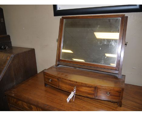 An early 19th Century rectangular swing toilet mirror on slender reeded supports, the bowfront base with banded edge, fitted 
