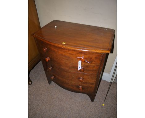 A small 19th Century mahogany bowfront commode with moulded edge, dummy drawer front with turned wood knob handles, raised on