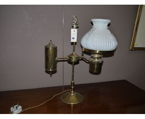A counter balance lamp with opaque moulded glass shade, raised on a brass column with circular plinth base.