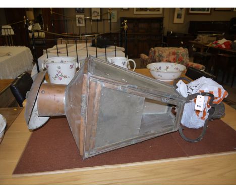 An old copper square-shaped tapering street lamp with four glazed panels, complete with hanging bracket but no inside.