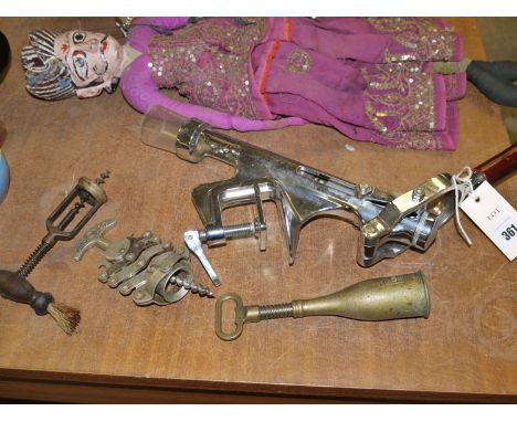 A large chromed metal commercial bench mounted cork screw; a zig zag cork screw; a brass champagne cork screw; and an antique