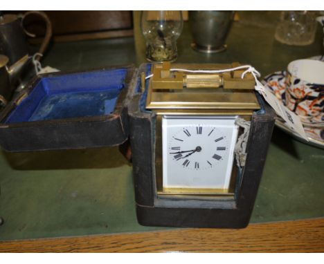 A late 19th Century carriage clock, with visible escapement and leather travelling case (case distressed); together with a sm